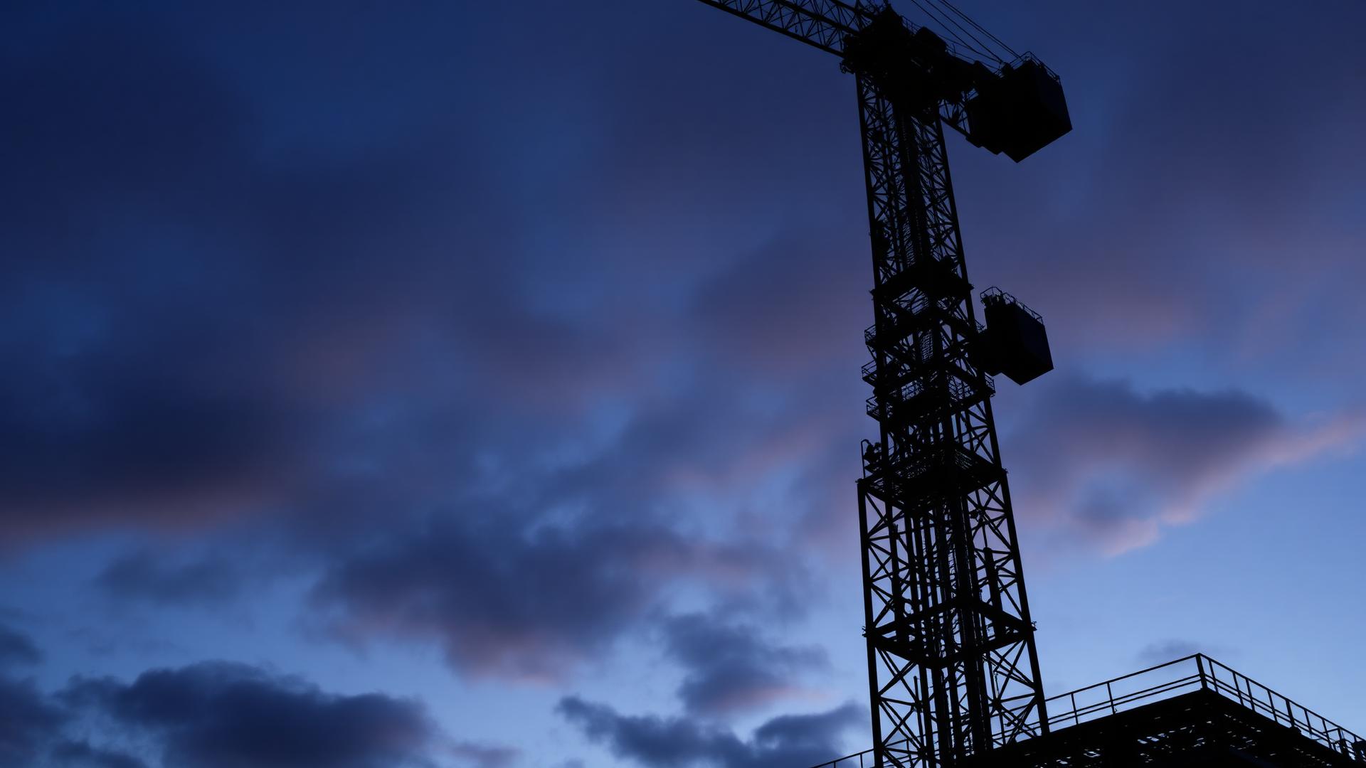 Torenkraan boven een bouwplaats bij laag licht